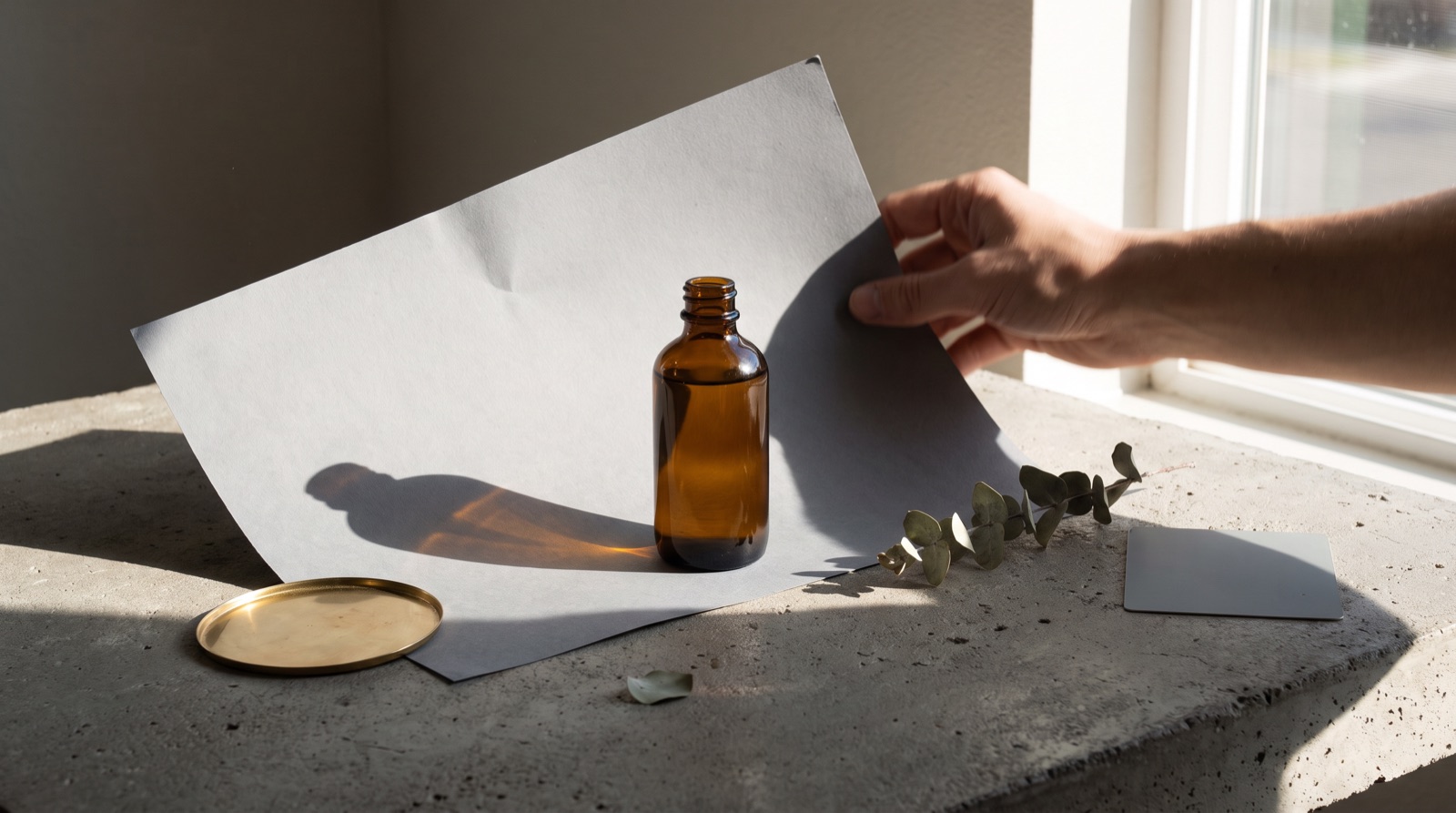 A grid of ad creative thumbnails in different visual styles fanned out beside a single product photo, on a warm cream background.