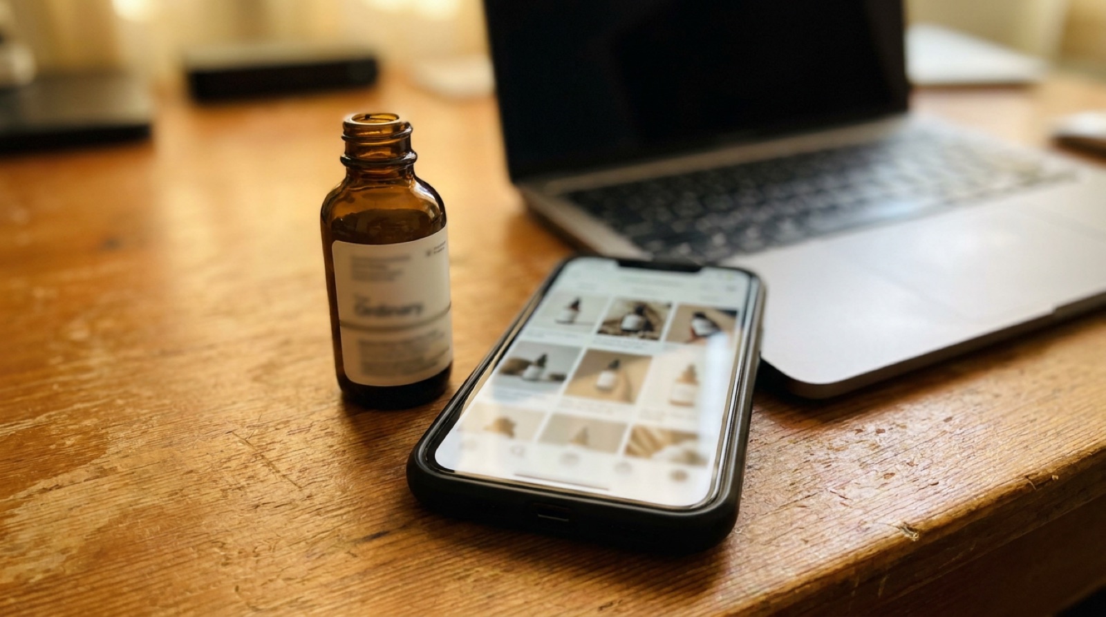 A product bottle beside a phone showing a grid of AI-generated product-shot variations on a warm desk.